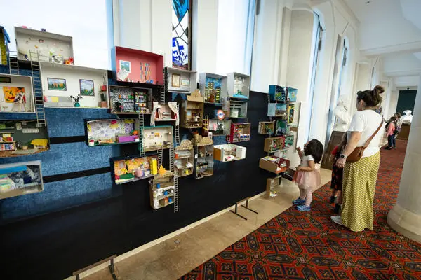 Mum and child looking at an installation made of show boxes